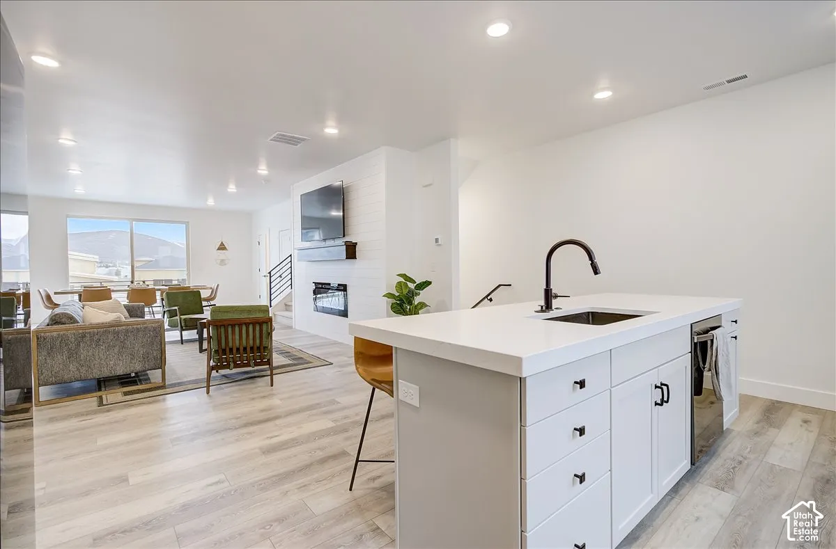 Kitchen island with a matte black faucet and under-counter dishwasher