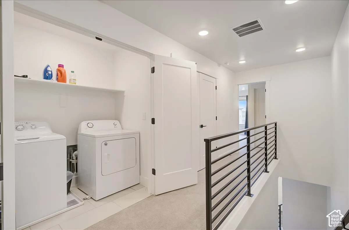 Dedicated laundry area with built-in shelving, tile flooring, and recessed lighting