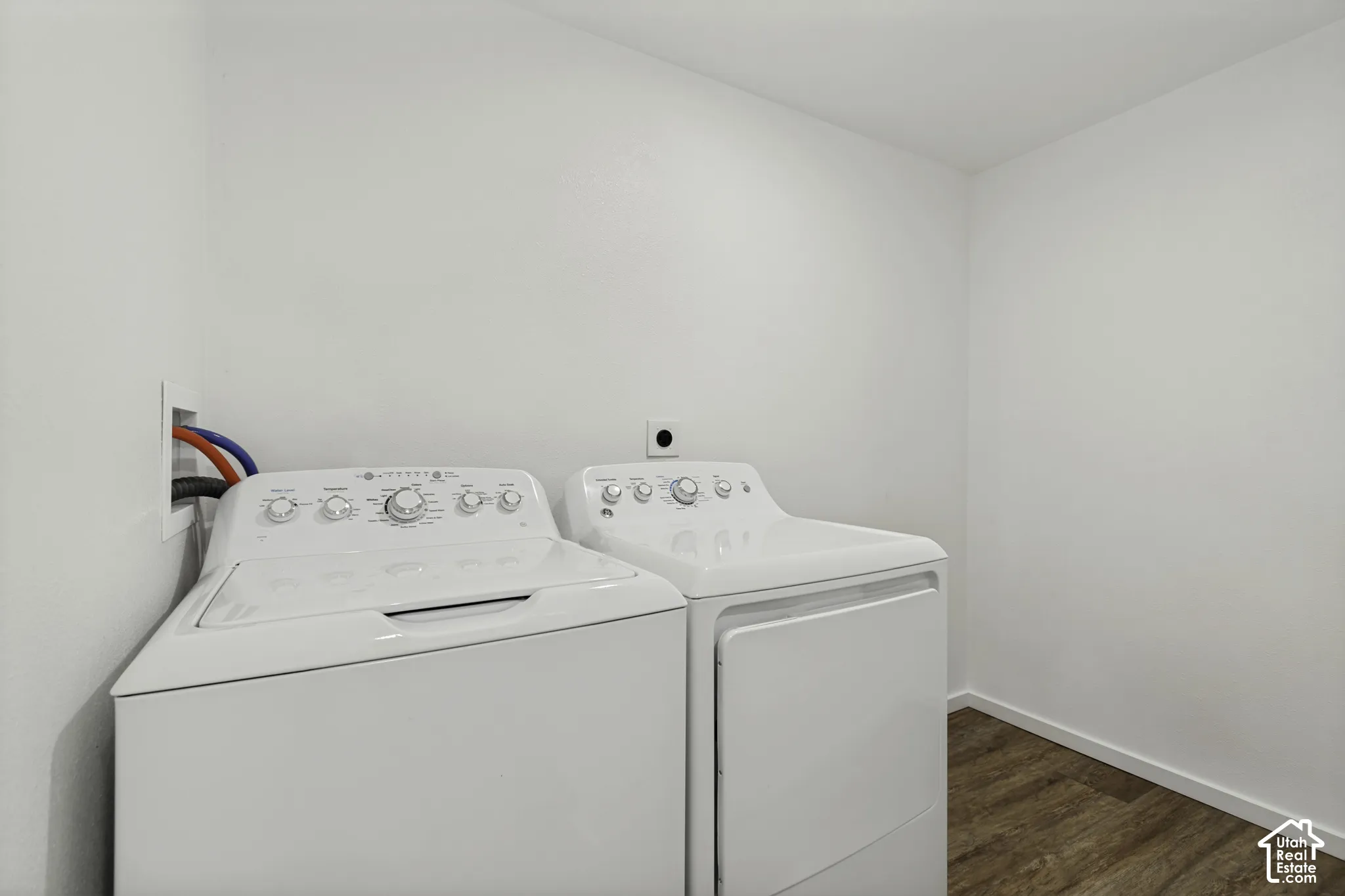 Dedicated laundry space with durable wood-finish flooring and light-toned walls