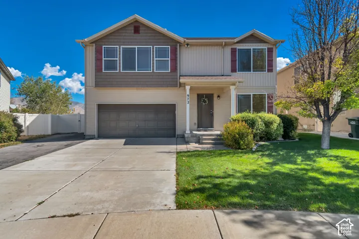 Two-story exterior with two-car garage, covered porch entry, and mature landscaping