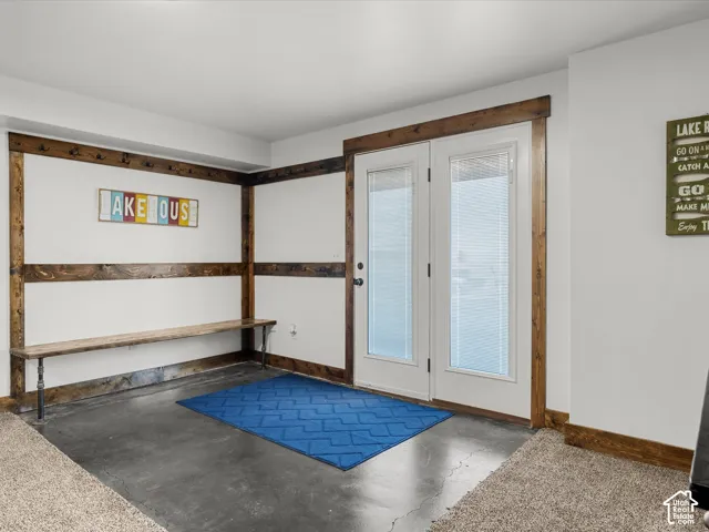 Basement Entry area featuring concrete flooring, white walls, and wood-finish trim