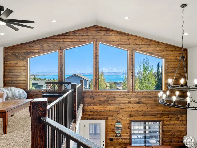 2nd floor family room lake view.  Vaulted wood-paneled wall with expansive windows, offering a distant lake and mountain backdrop