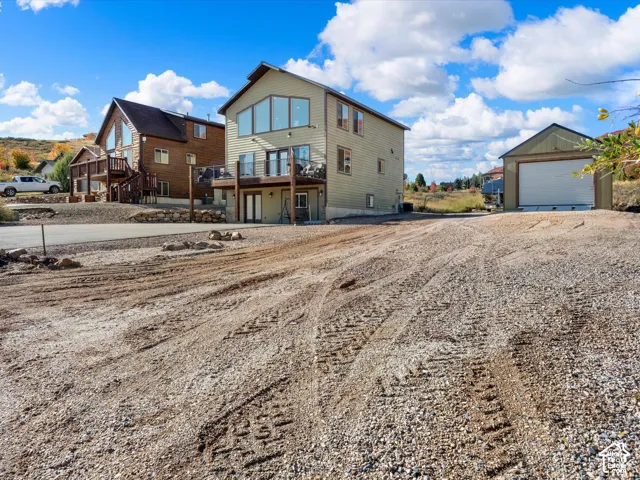 Gravel driveway with a detached garage featuring an overhead door