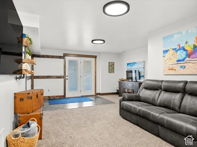 Recessed lighting, wood-trimmed double doors with frosted glass, and neutral carpeting