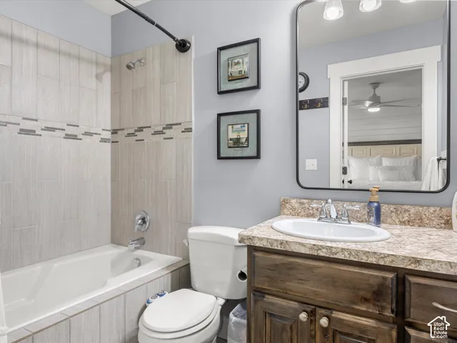 2nd floor Bathroom featuring a tub/shower combination with tiled surround, a vanity with a surface-mounted sink, a large framed mirror, and built-in vanity cabinetry