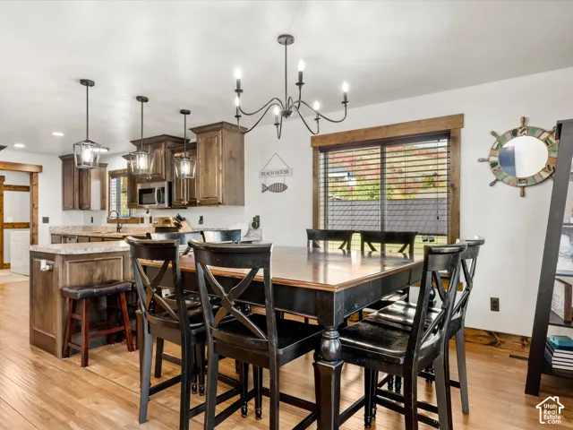 Wood-finish flooring, recessed lighting, and a chandelier illuminate this space