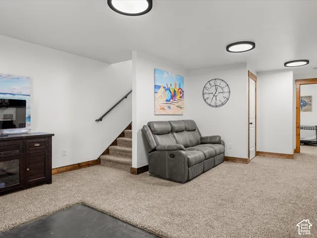 Lower level family room.  Carpeted flooring, white walls, wood-finish trim, and recessed lighting