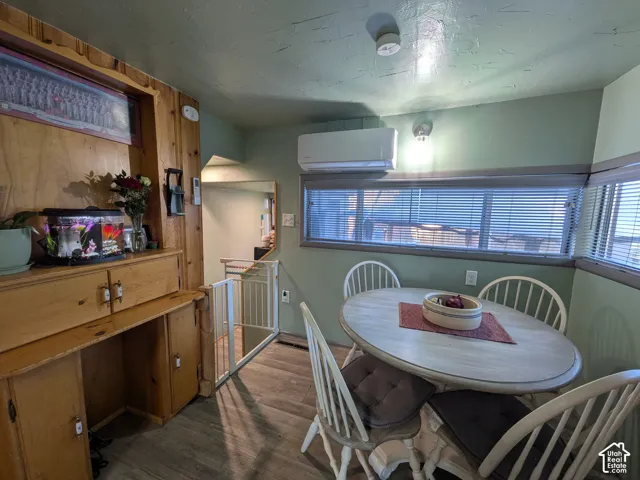 Built-in wood cabinetry, wood-finish flooring, and multiple windows with blinds