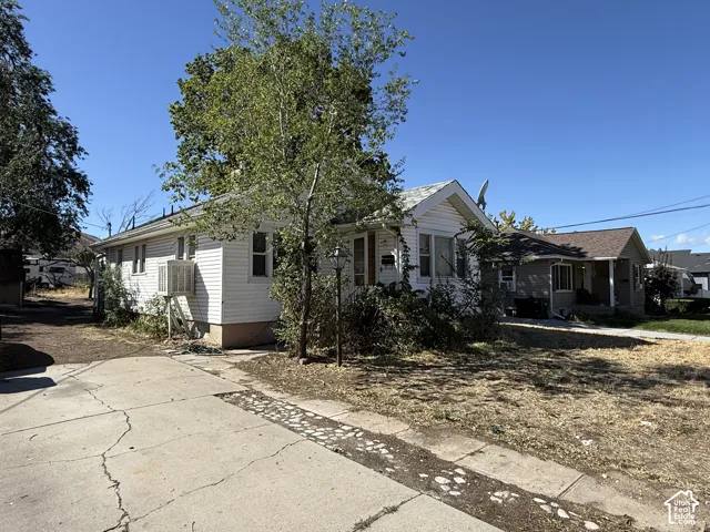 White siding exterior with a pitched roof and a concrete driveway