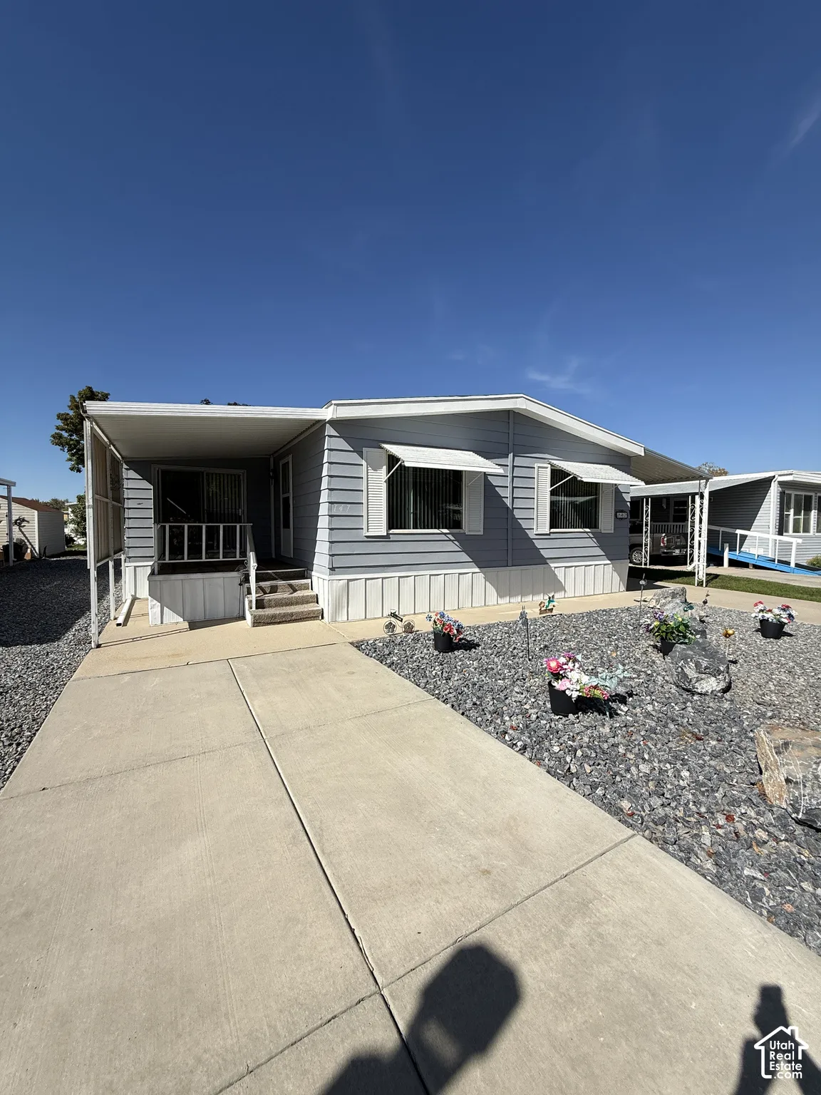 Light blue siding exterior with white trim and window awnings