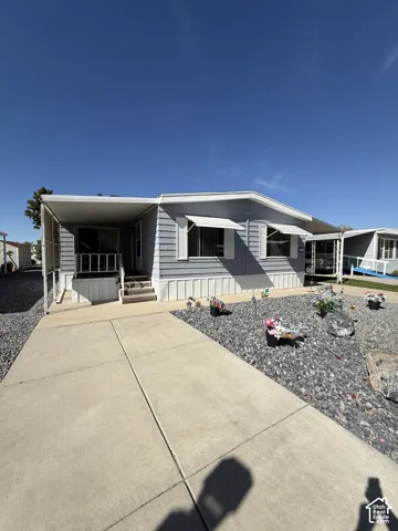 Light blue siding exterior with white trim and window awnings