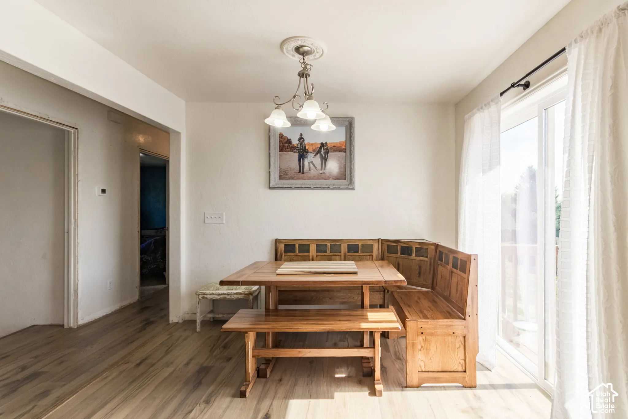 Wood-finish flooring throughout, with a built-in banquette seating area and sliding glass door