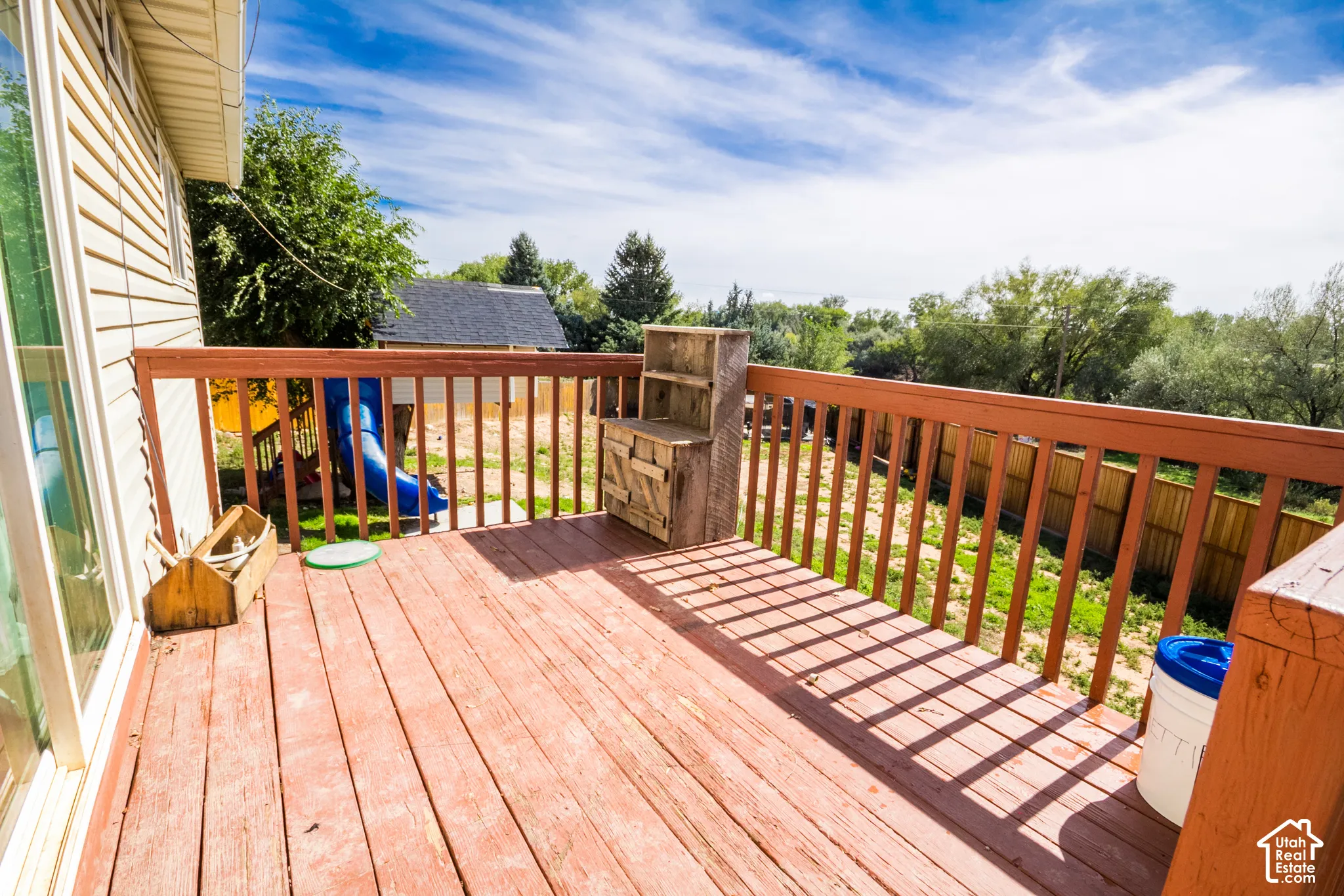 Wood-finish deck with a wood railing, siding exterior, and a sliding glass door