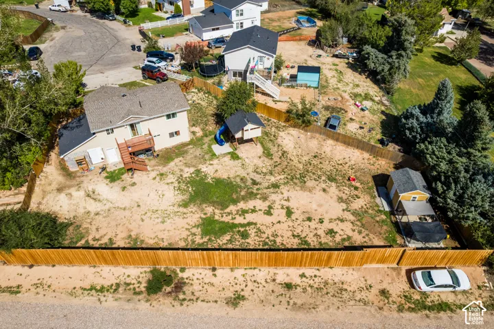 Expansive lot featuring a full wood privacy fence and a dedicated outbuilding with a covered patio