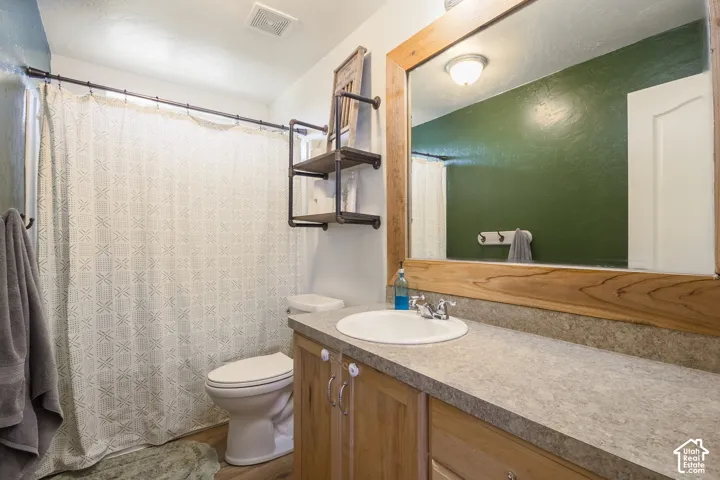 Wood-finish vanity with a single basin sink and chrome faucet