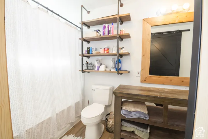 Wood-finish flooring, industrial-style shelving, and a natural wood-framed mirror