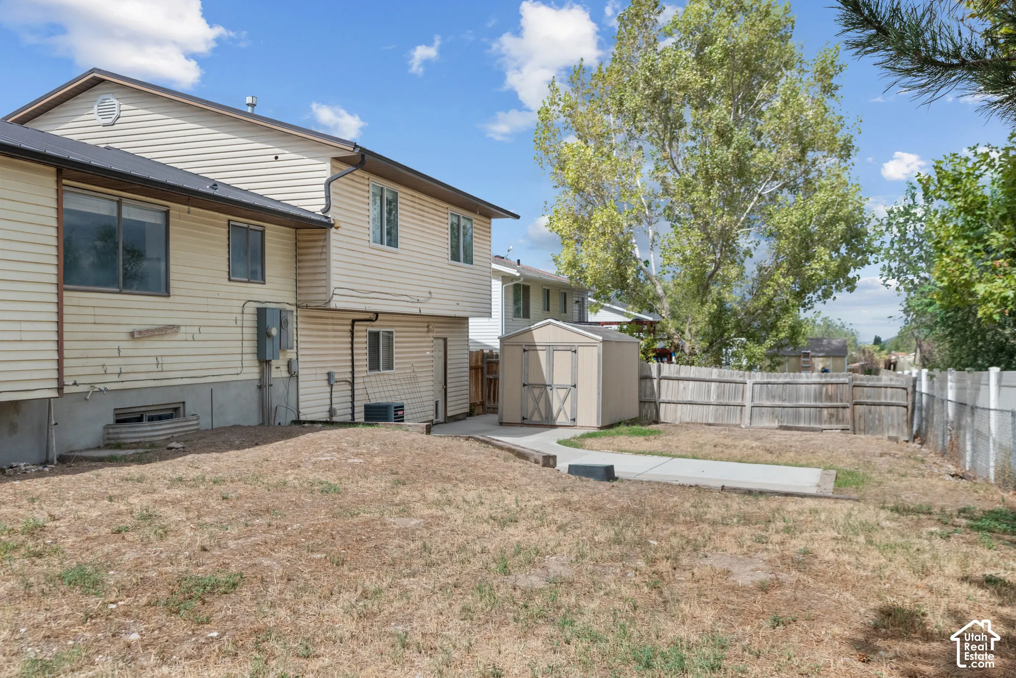 Fenced backyard with concrete patio