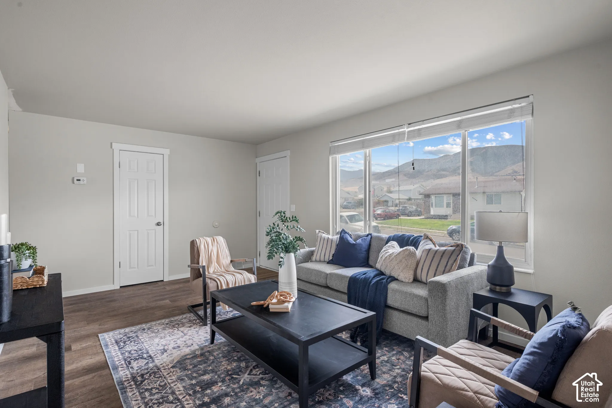 Spacious interior featuring wood-finish flooring, a large picture window, and light-toned wall finishes