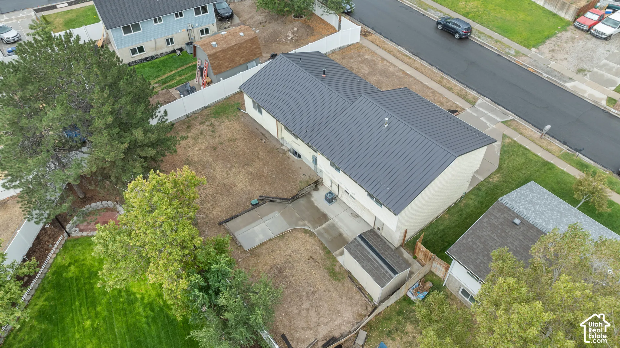 Contemporary style residence with a dark metal roof, light-toned exterior siding, and an attached garage