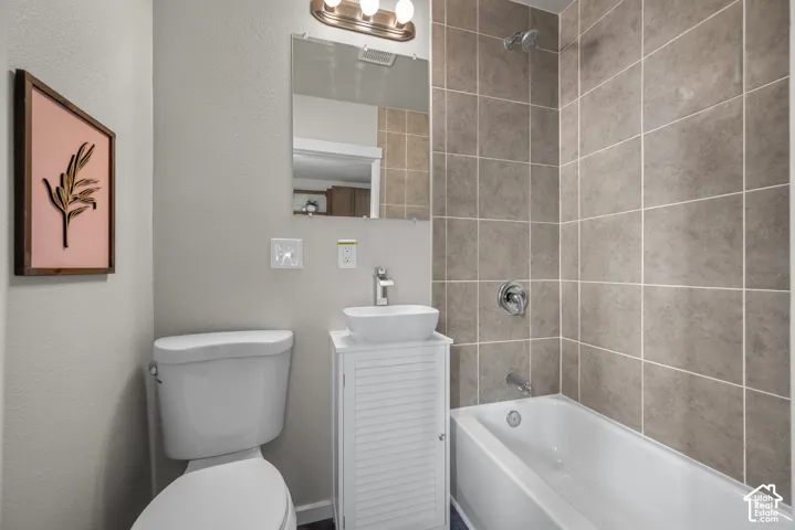 White freestanding vanity with a vessel sink, chrome faucet, and mirrored medicine cabinet