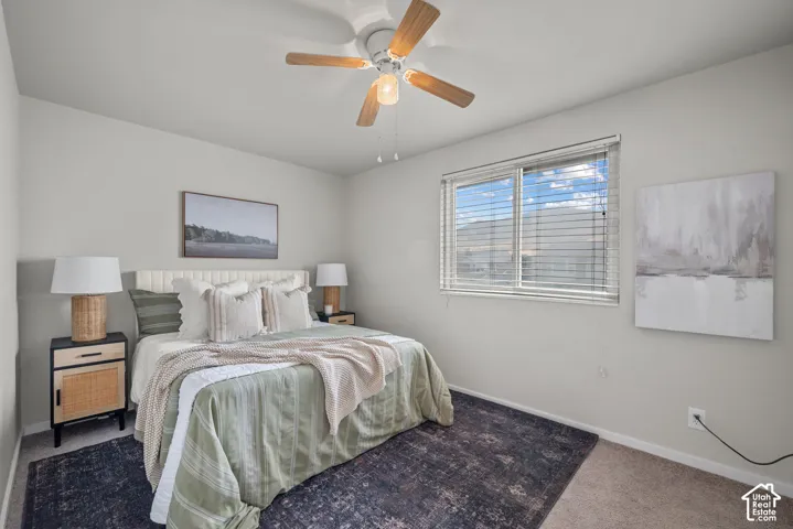 Ceiling fan with light fixture, window with blinds, light-toned walls, and carpet flooring