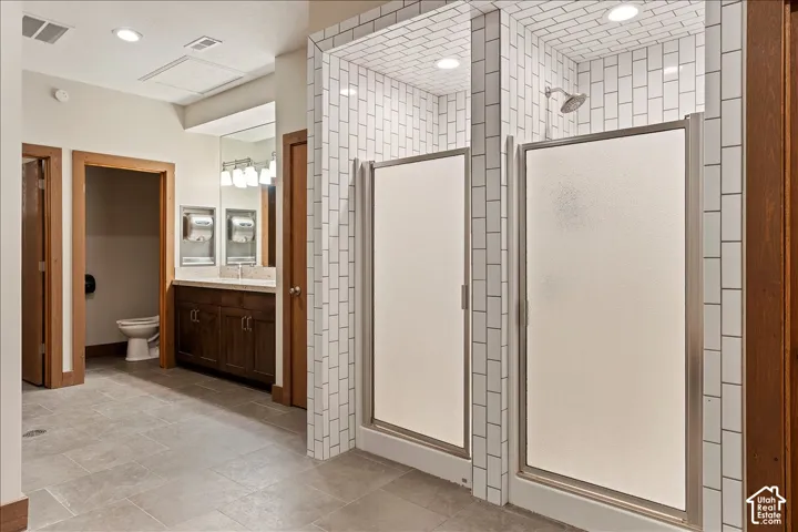 Multiple shower stalls with white subway tile surrounds