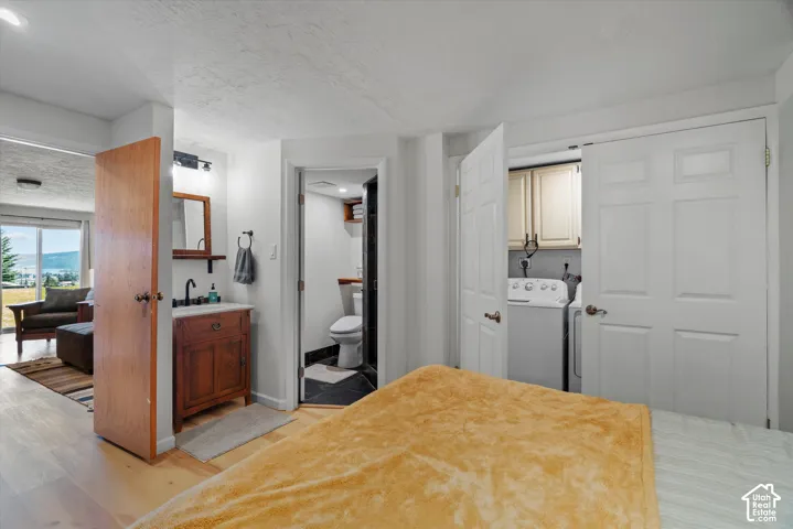 Wood-finish flooring with a vanity featuring a vessel sink and matte black faucet