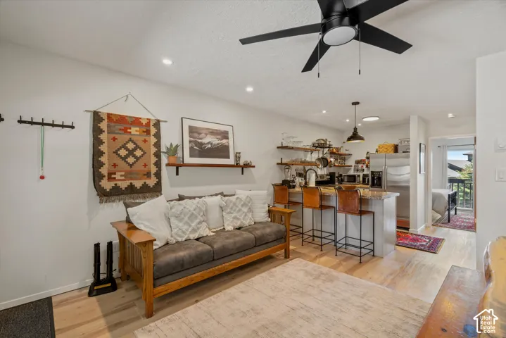 Open-concept living space featuring light wood-finish flooring, recessed lighting, and a ceiling fan
