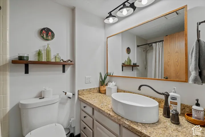 Granite-finish countertop featuring an oval vessel sink and a wall-mounted wood-frame mirror