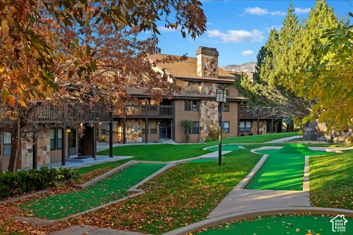 Multi-story building featuring stone and siding exterior, private balconies, and a built-in stone chimney