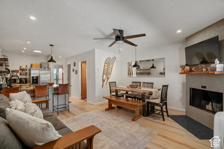 Open-concept living area featuring light wood-finish flooring, recessed lighting, and a ceiling fan