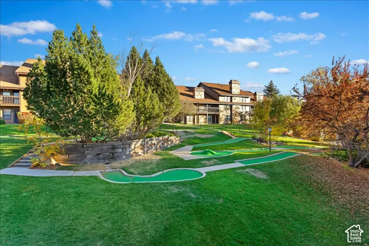 Expansive lawn area featuring a multi-hole putting green and mature trees