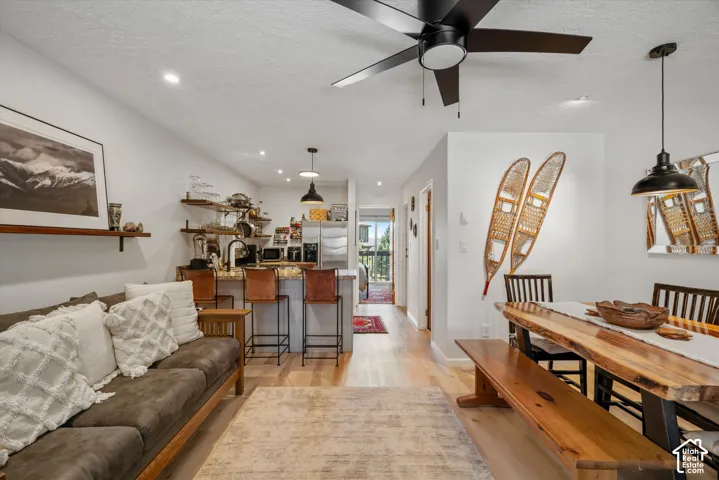 Open-concept living area featuring wood-finish flooring, a contemporary ceiling fan, and recessed lighting