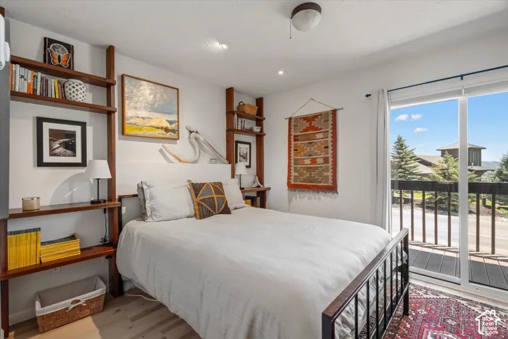 Sliding glass door opening to an exterior balcony with dark wood decking