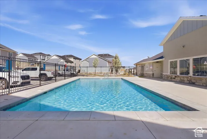 Outdoor swimming pool with a concrete surround and perimeter fencing