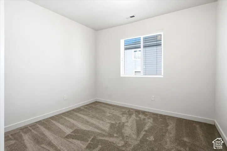 Neutral wall tones, recessed lighting, and a single window with blinds