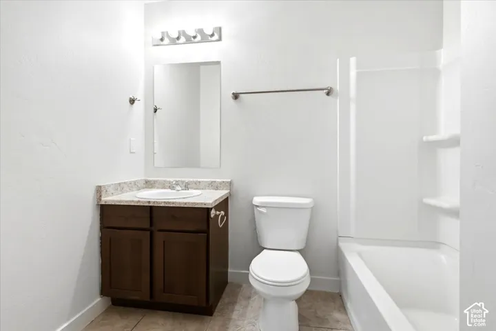 Bathroom featuring a single vanity with a white basin, dark wood-finish cabinetry, and a light-toned countertop