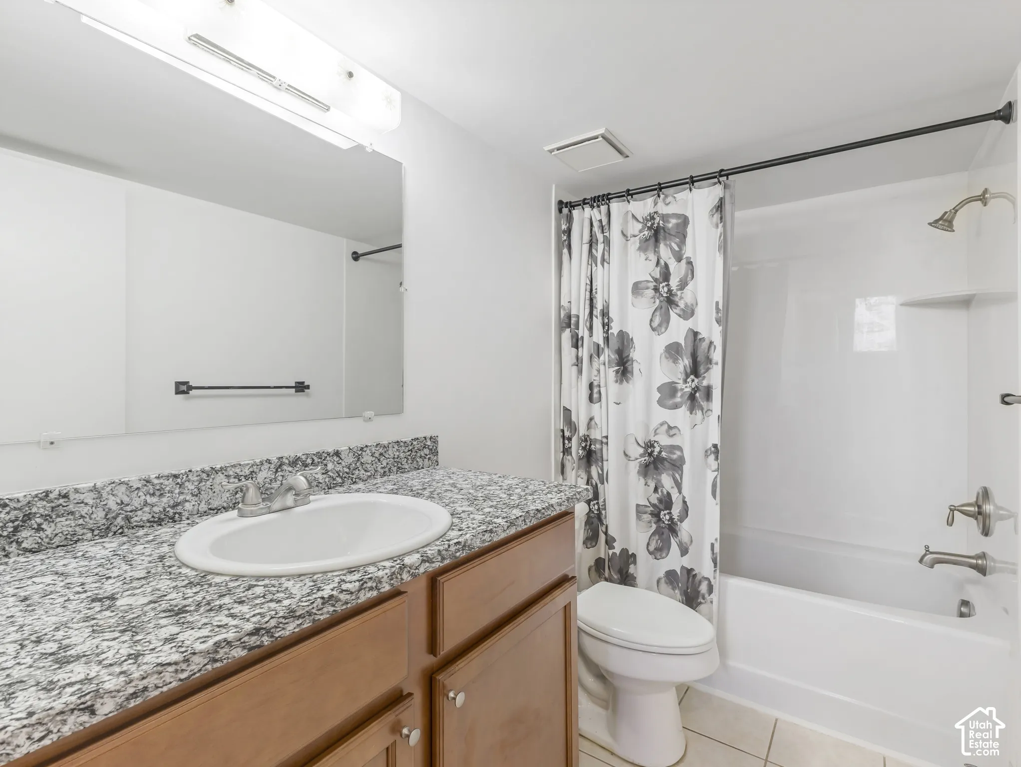 Bathroom featuring a white bathtub, vanity with a white oval sink, and granite countertop