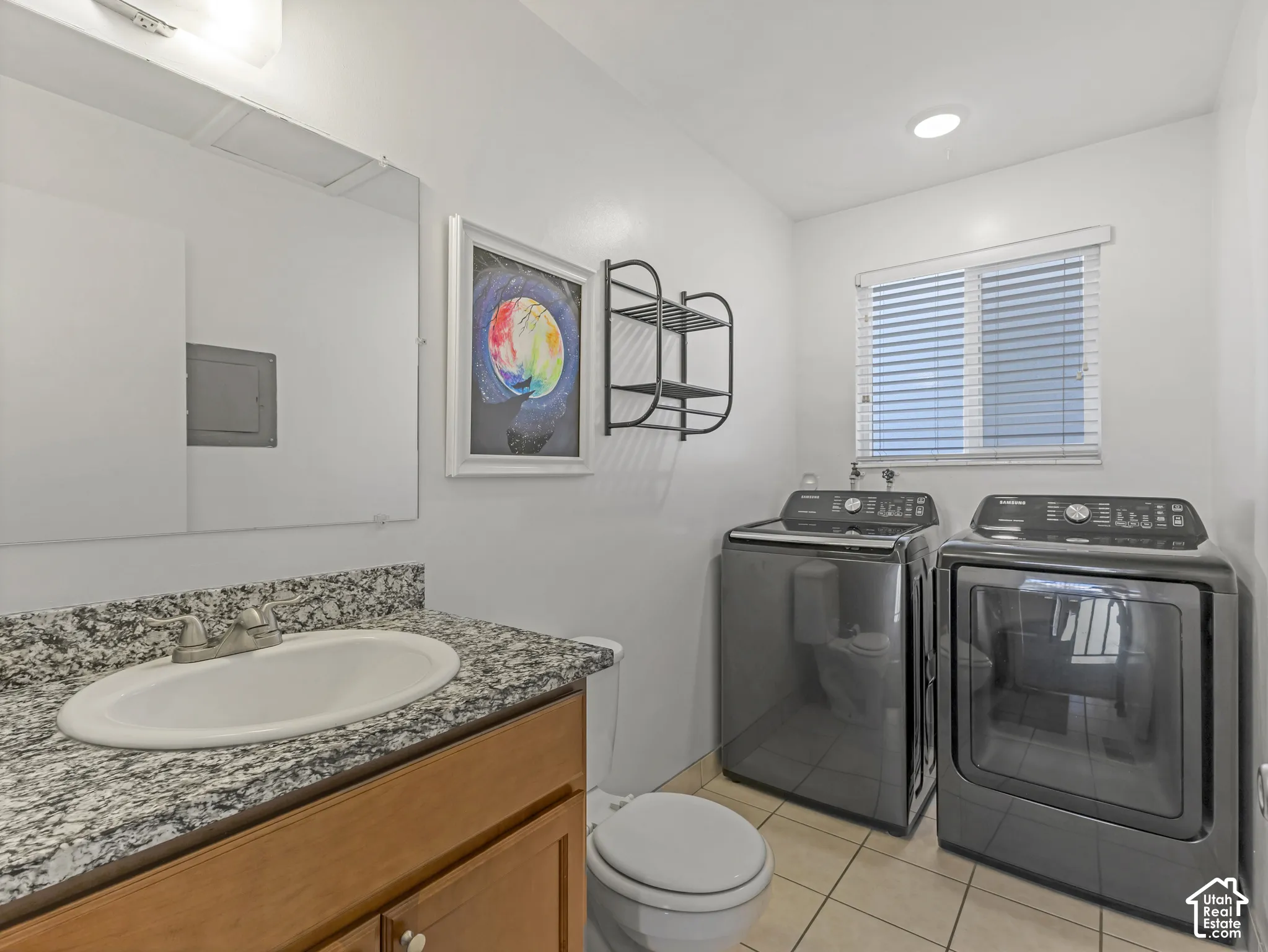 Half bath and laundry with a granite countertop and an integrated sink