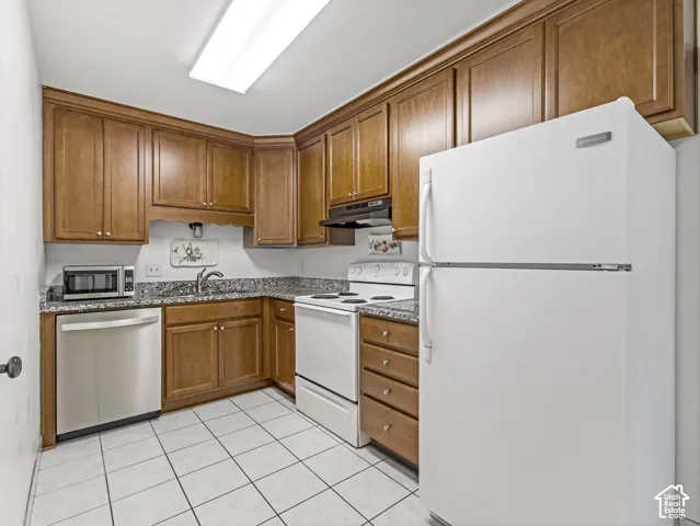 Wood-finish cabinetry, granite countertops, and tiled flooring