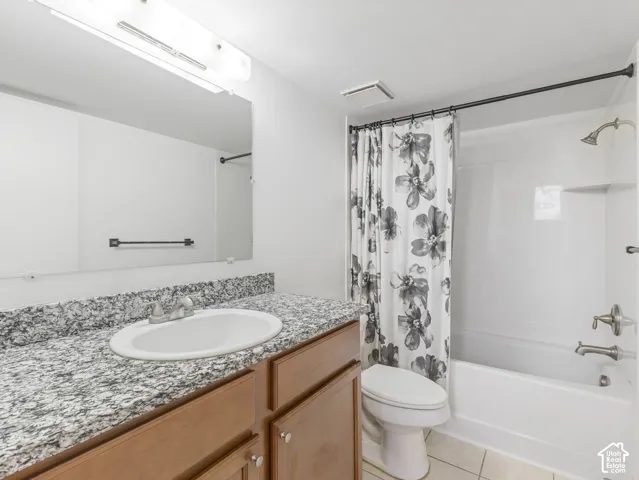 Bathroom featuring a white bathtub, vanity with a white oval sink, and granite countertop