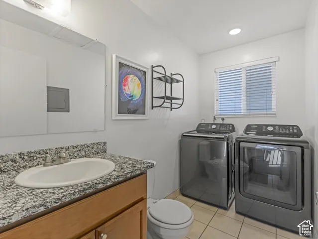 Half bath and laundry with a granite countertop and an integrated sink