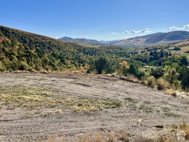 Expansive land parcel featuring distant mountain ranges and a verdant valley