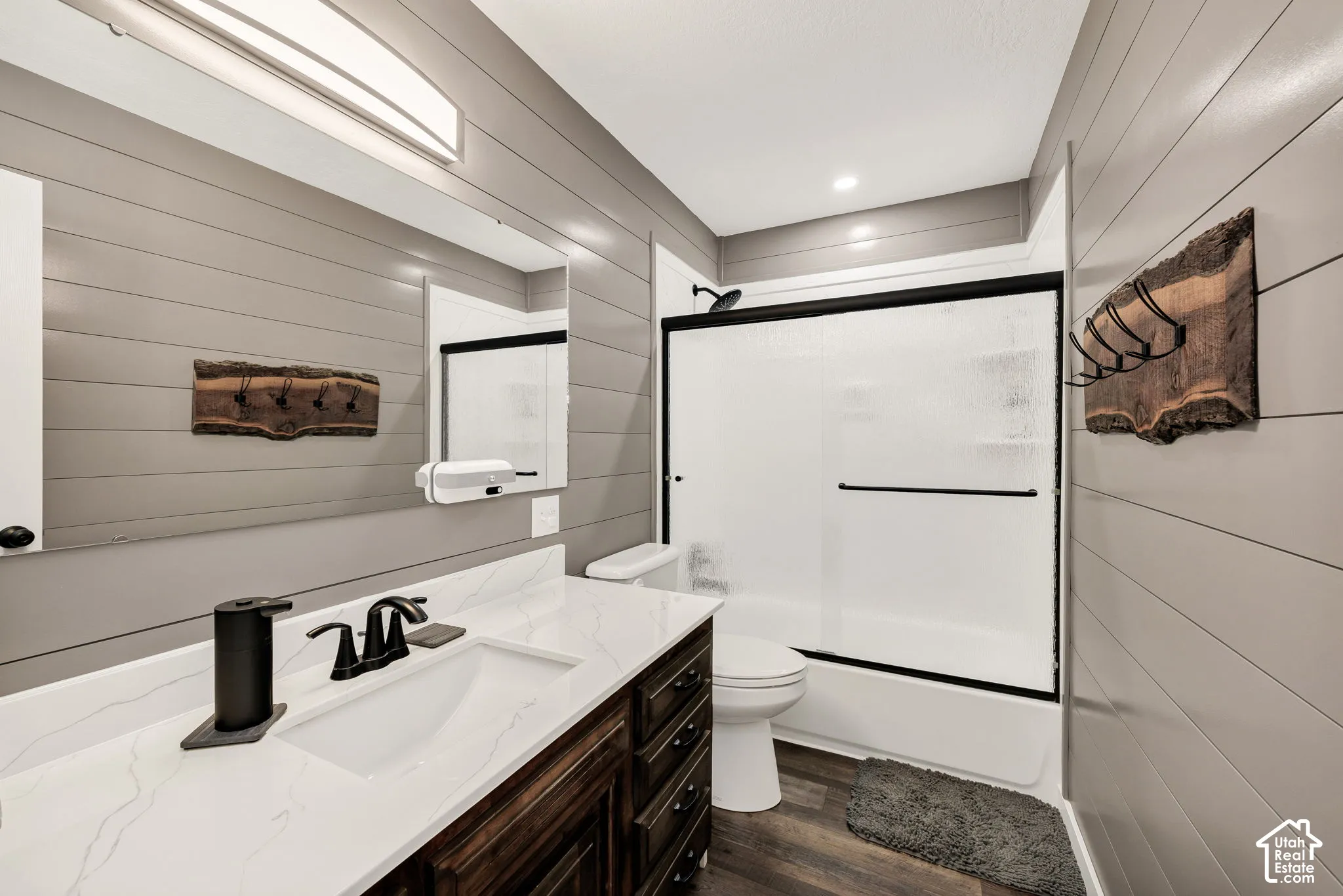 Vanity with integrated sink and dark wood-finish cabinetry