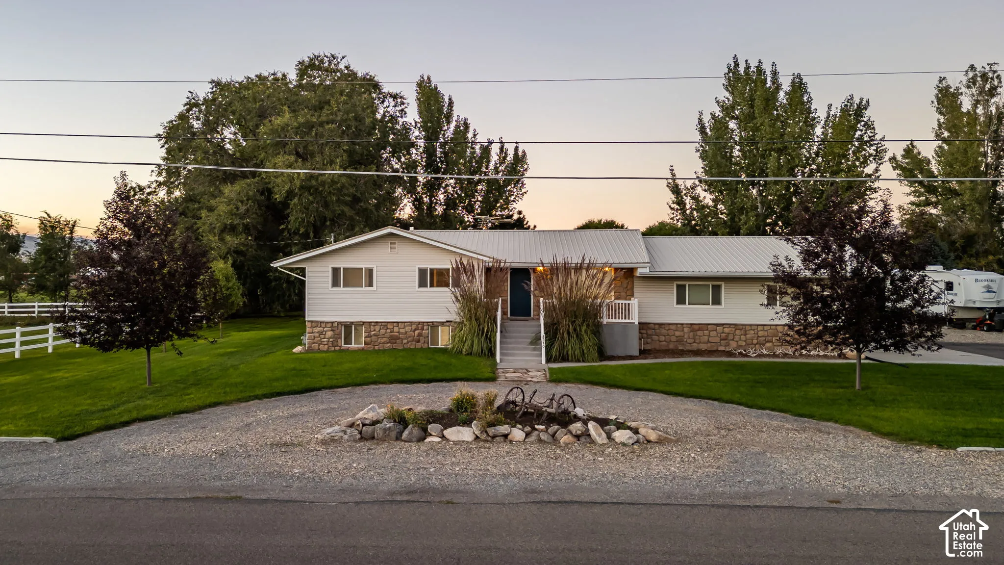 Ranch-style exterior with a metal roof and stone foundation