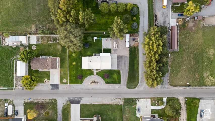 Expansive lot featuring a primary residence, detached outbuilding, and mature trees