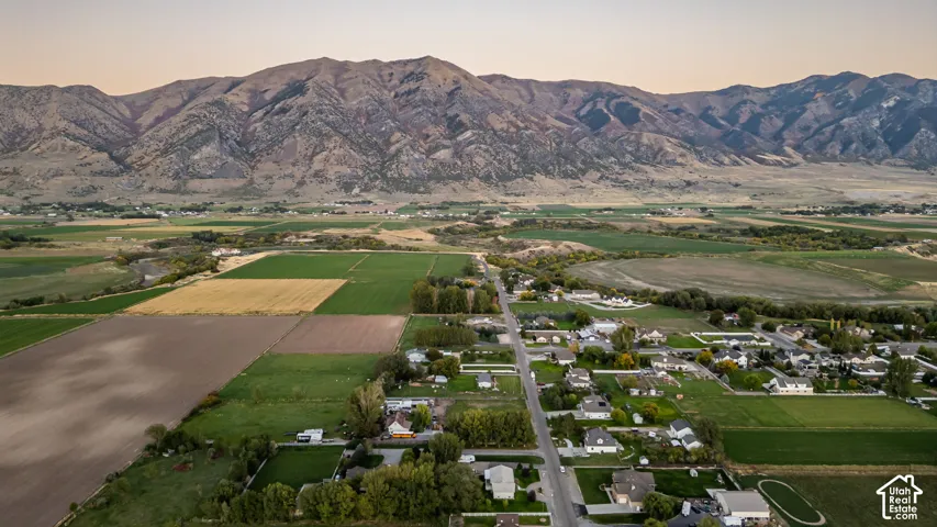 Mountain backdrop overlooking a rural community with agricultural fields and residential properties