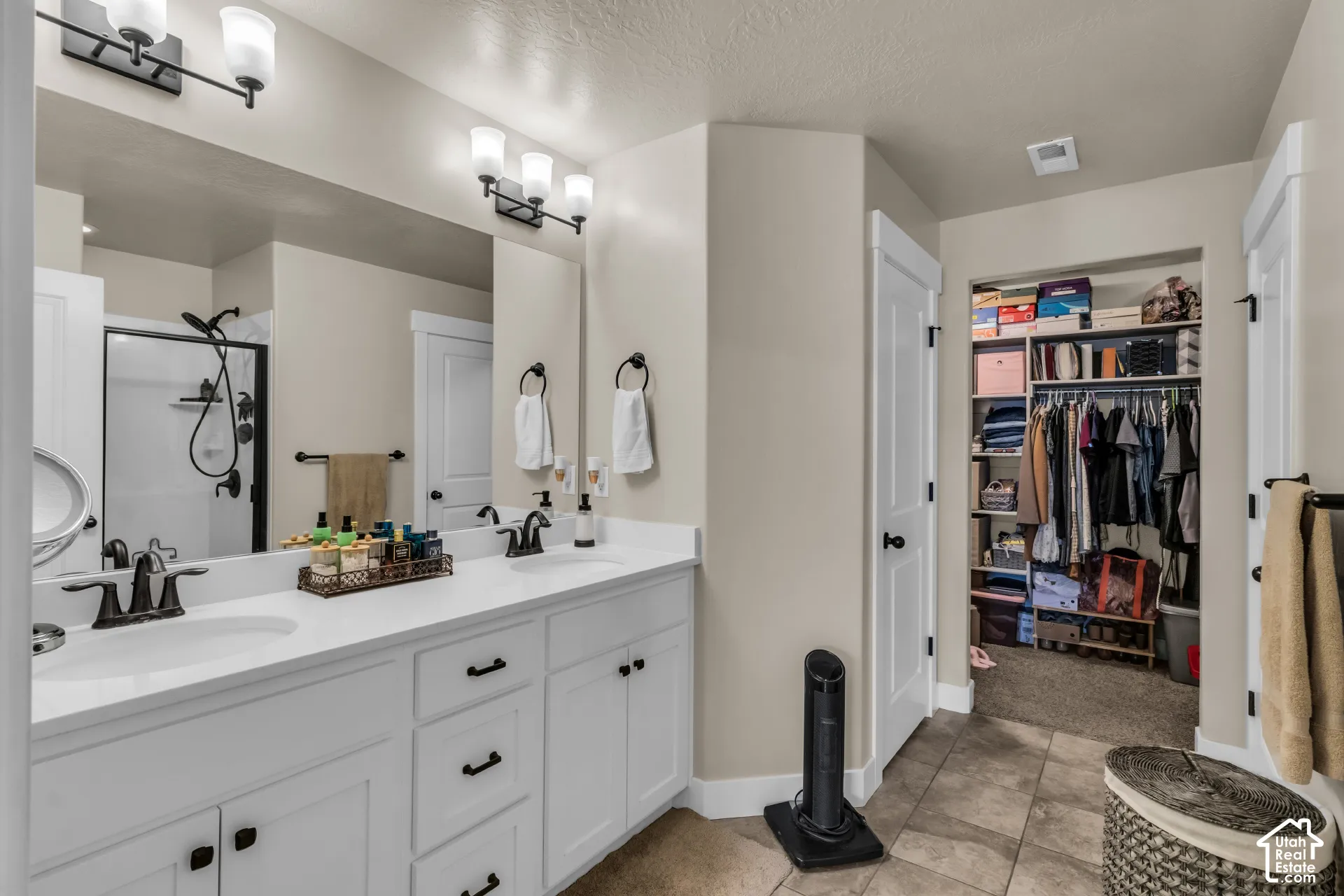 Dual vanity with white cabinetry, integrated sinks, and dark fixtures