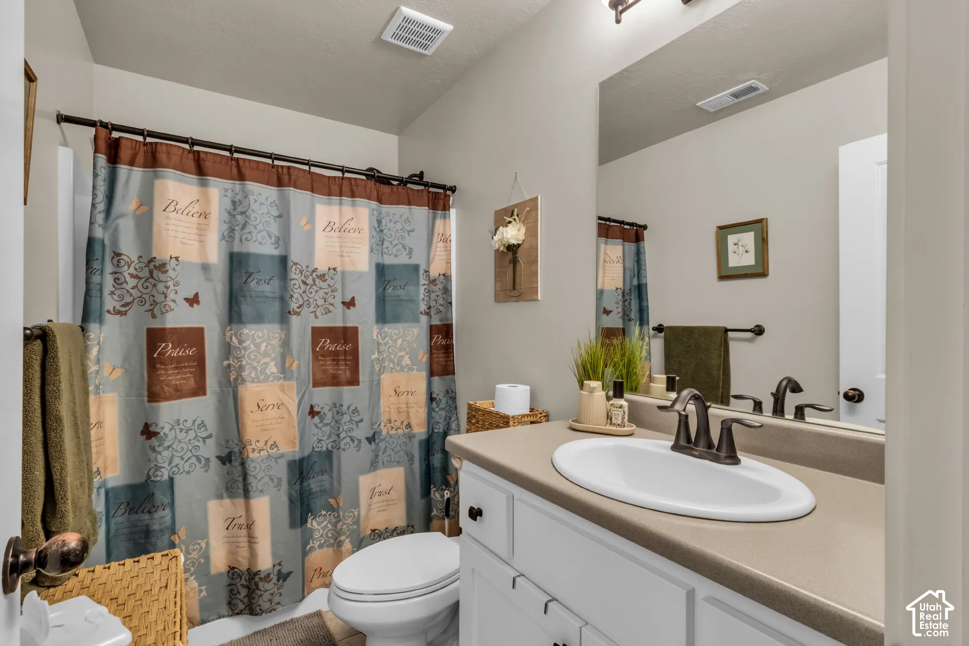 Vanity with an integrated sink, dual-handle faucet, and an expansive mirror