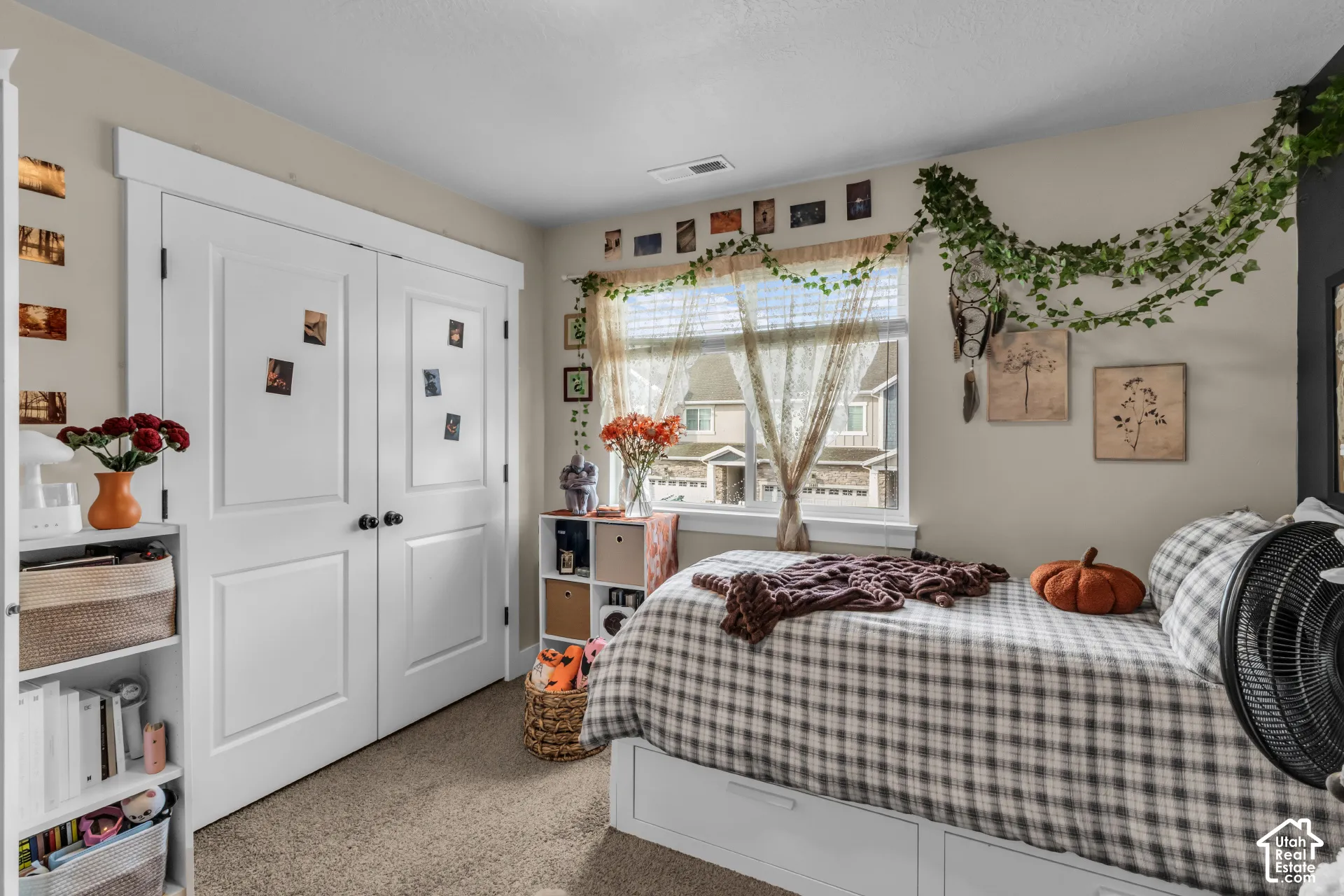 Built-in closet with panel doors and dark hardware, window with natural light, and carpeted flooring